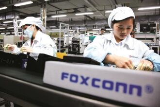 Workers assembling electronic components on a production line at a Foxconn manufacturing facility in Vietnam.