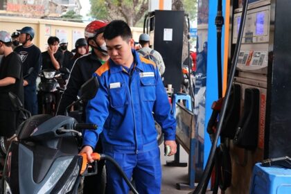 A worker fills a motorbike at a station as Vietnam extends fuel tax relief to stabilize energy prices in 2026.