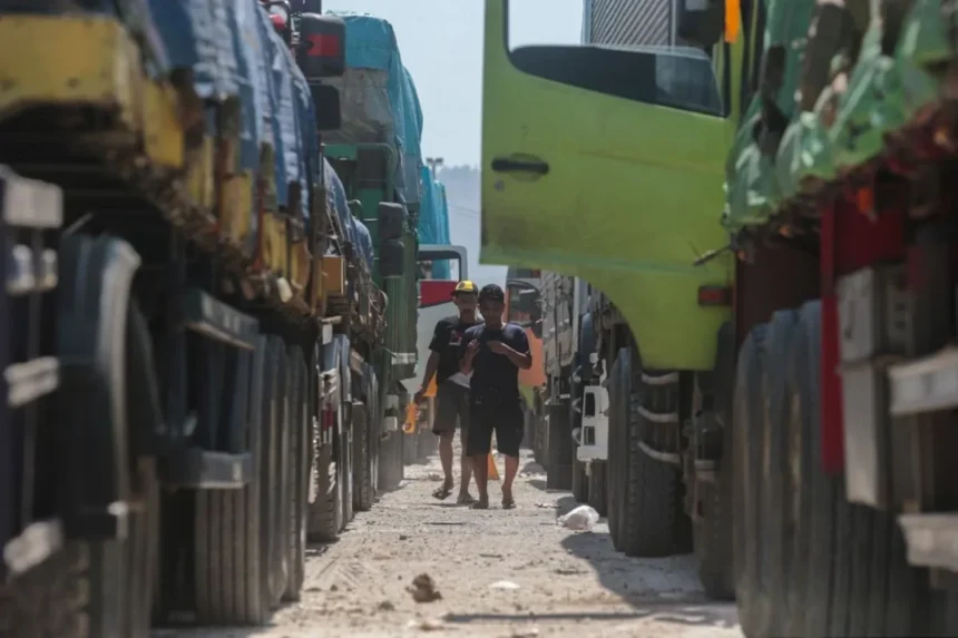 Drivers walk between rows of parked freight trucks during the holiday transport restrictions for national logistics.