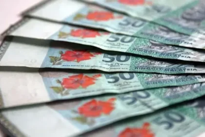A fan of 50 Malaysian ringgit banknotes showcasing the national hibiscus flower and traditional songket patterns.
