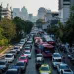 A busy city street in Thailand where economic shifts and foreign fund movements impact national bonds and stability.