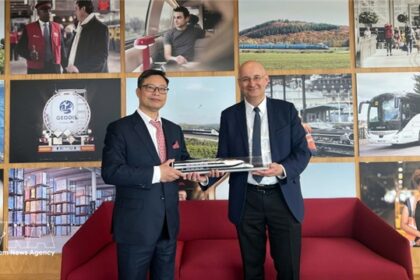 Vietnamese and French officials hold a high-speed railway model during a meeting on transport infrastructure.