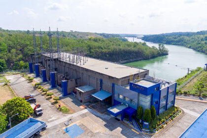 Aerial view of an AboitizPower hydroelectric facility nestled within a lush river landscape in the Philippines.