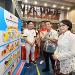 Participants at a DBS POSB community event showcasing daily essential price tags for the heartland support program.