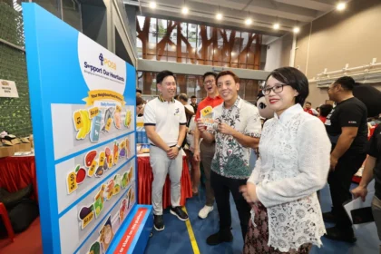 Participants at a DBS POSB community event showcasing daily essential price tags for the heartland support program.