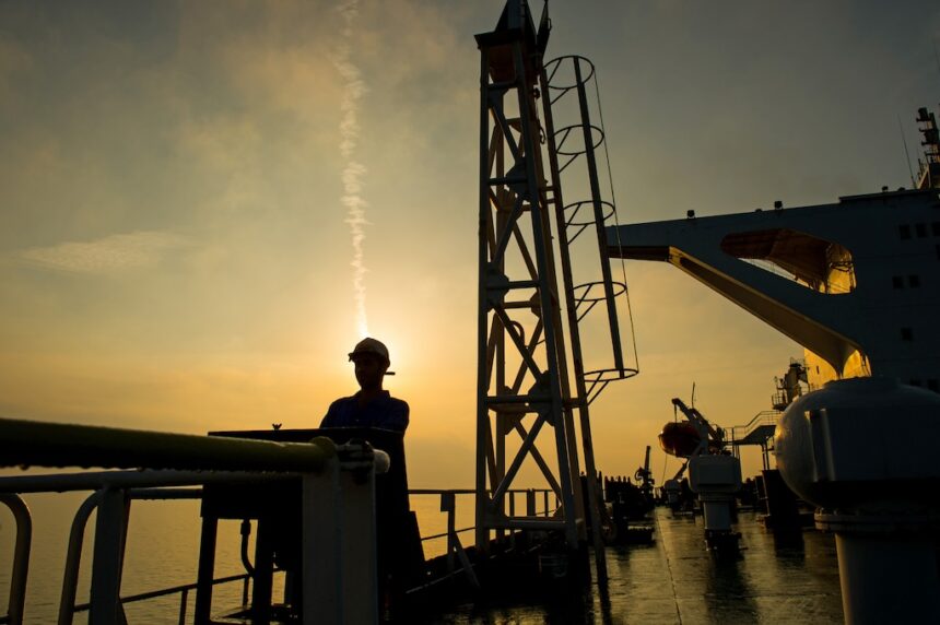 A worker on an offshore platform managing operations that support national energy subsidies and security.