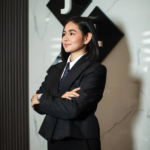 Jill Tolentino, President of JLT Group, posing in front of the corporate logo at the company headquarters.