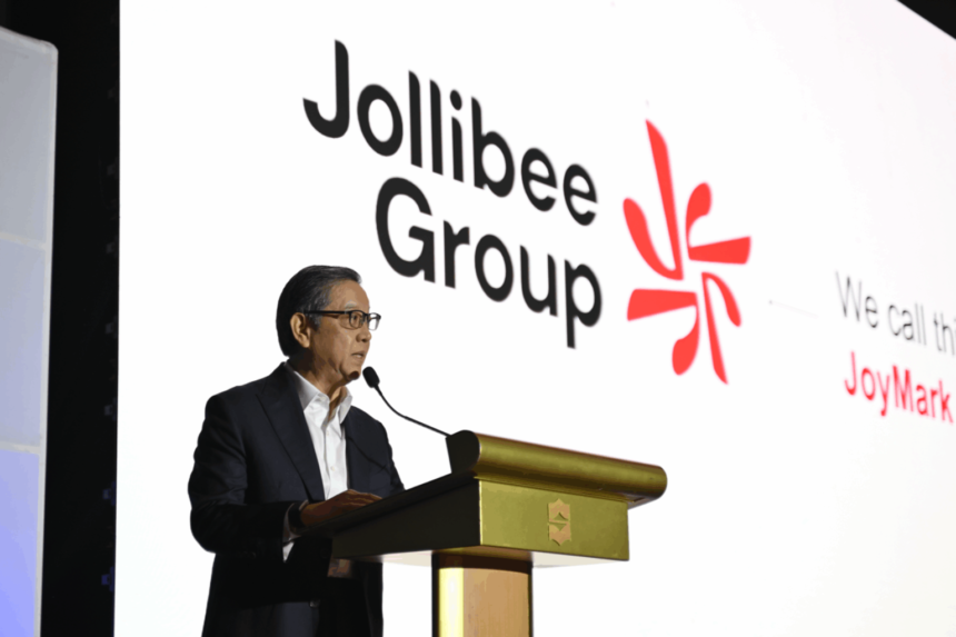 Tony Tan Caktiong speaking at a podium with the Jollibee Group logo displayed prominently in the background.