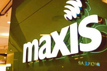 Close-up of the official Maxis logo illuminated on a store exterior in Malaysia.