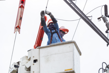 Utility workers in a bucket truck performing maintenance on power lines to ensure service reliability for Meralco.