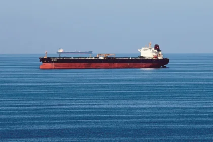 Oil tankers idle in open water as OPEC+ production quotas are discussed amidst regional maritime disruptions.