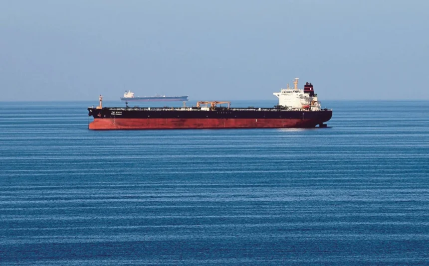 Oil tankers idle in open water as OPEC+ production quotas are discussed amidst regional maritime disruptions.