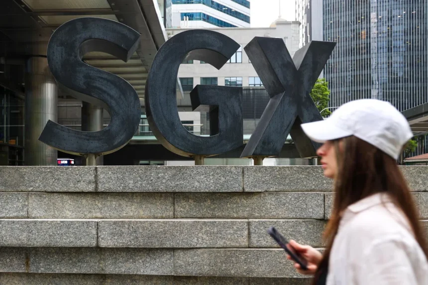A pedestrian walks past the SGX building in Singapore, where companies listed on the STI are traded daily.
