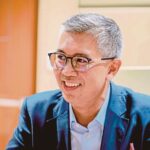 A portrait of Tengku Zafrul smiling during an interview, representing Malaysian economic leadership.