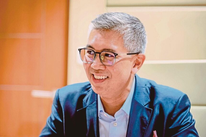 A portrait of Tengku Zafrul smiling during an interview, representing Malaysian economic leadership.