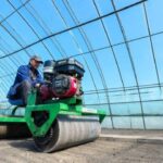 A farmer operating machinery inside a greenhouse, illustrating industrial agricultural growth within The Philippines economy.
