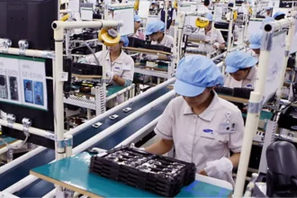 Workers in a processing factory assemble electronic components, driving industrial output and the national economy.