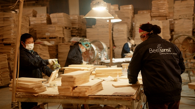 Workers at an assembly line manufacture wood, a key sector for Vietnamese online exporters in global trade.