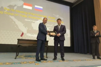 Representatives from Indonesia and Russia exchange gifts during a meeting to strengthen the WGTB framework.