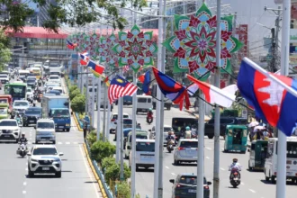 A busy street in Cebu lined with ASEAN member state flags and colorful decorative stars during the regional summit.