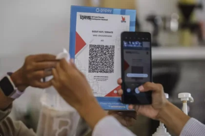 A customer scans a QRIS code to complete a cross border transaction via the Alipay network using a mobile app.
