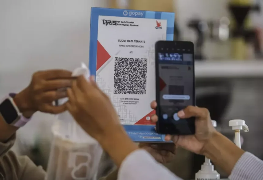 A customer scans a QRIS code to complete a cross border transaction via the Alipay network using a mobile app.