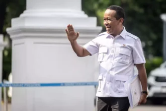 Minister Bahlil Lahadalia waving to reporters after confirming exemptions for the upstream oil and gas sector.