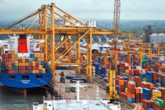 Container ship at a busy port, loading electronics for export.