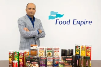 CEO Sudeep Nair posing with various Food Empire beverage and snack products next to the company logo.
