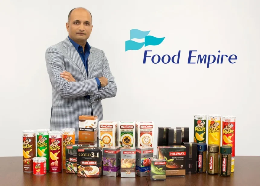 CEO Sudeep Nair posing with various Food Empire beverage and snack products next to the company logo.