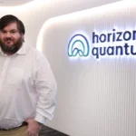 CEO Joe Fitzsimons standing in front of the Horizon Quantum office logo in Singapore.