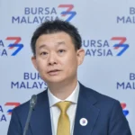 Executive director Wong Chong Siong of Inspace Creation speaking at a press conference in front of a Bursa Malaysia backdrop.