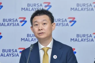 Executive director Wong Chong Siong of Inspace Creation speaking at a press conference in front of a Bursa Malaysia backdrop.