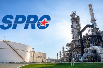 Industrial view of the SPRC oil refinery complex featuring large storage tanks and processing towers under a clear sky.