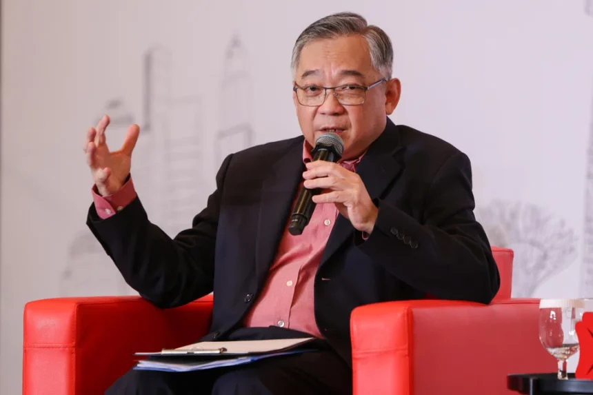 Minister Gan Kim Yong speaking into a microphone during a financial hub panel discussion on global AI strategies.