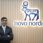 Jay Thyagarajan standing in front of the illuminated Novo Nordisk corporate logo at the regional headquarters.