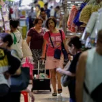 Shoppers at a local market in Manila navigate rising costs following the global oil shock affecting the region.