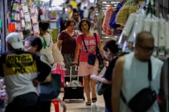 Shoppers at a local market in Manila navigate rising costs following the global oil shock affecting the region.