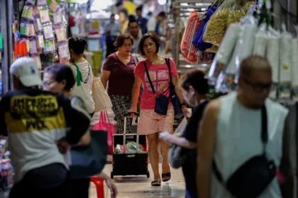 Shoppers at a local market in Manila navigate rising costs following the global oil shock affecting the region.