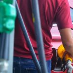 A gas station worker refueling a car amid recent weekly adjustments to domestic commercial retail fuel prices.