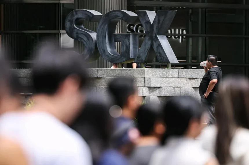 A large outdoor sign for the SGX Group stands behind a crowd of commuters, symbolizing the home market for suspended firms.