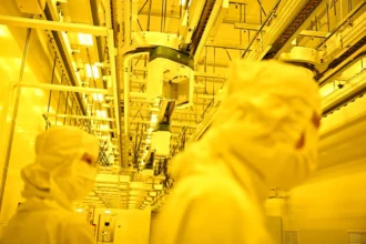 Workers in cleanroom suits producing AI-Related Electronics.
